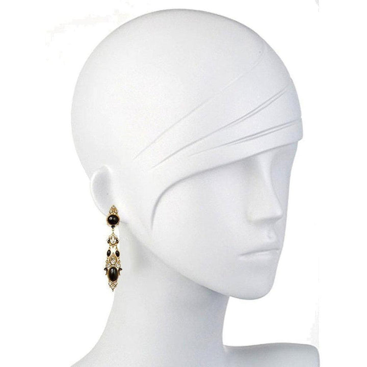 Elegant black onyx and topaz drop earrings on a mannequin.