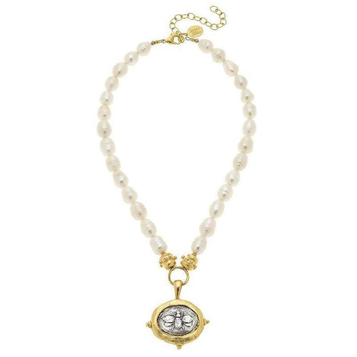 Elegant pearl necklace with gold-framed bee pendant.