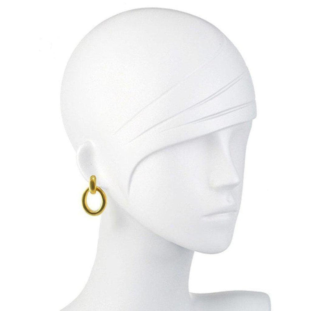 Gold teardrop hoop earrings on a mannequin.