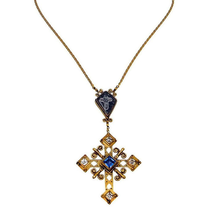 Gold cross necklace with blue and clear gemstones, intricate detailing.