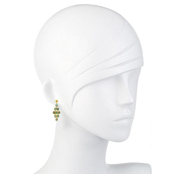 Gold opal drop earrings on a mannequin, showcasing teal gemstone accents.