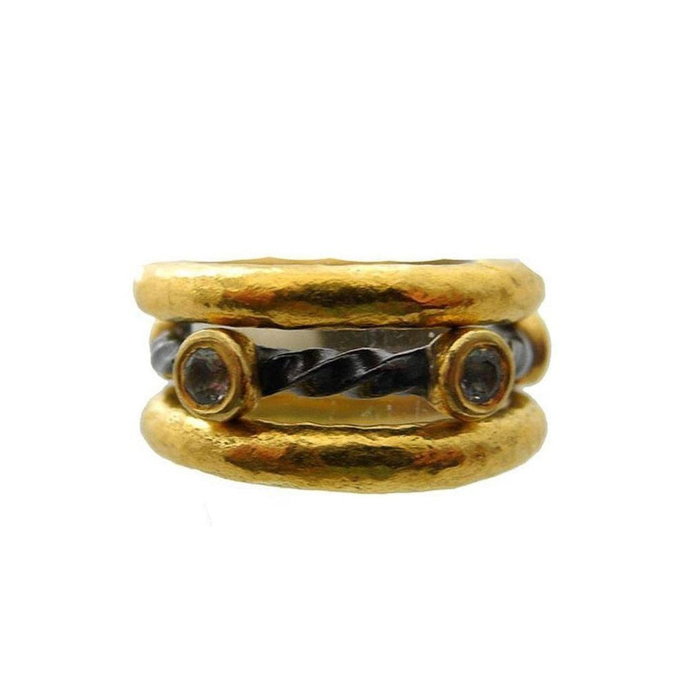 Gold and blackened metal ring featuring three gemstones.