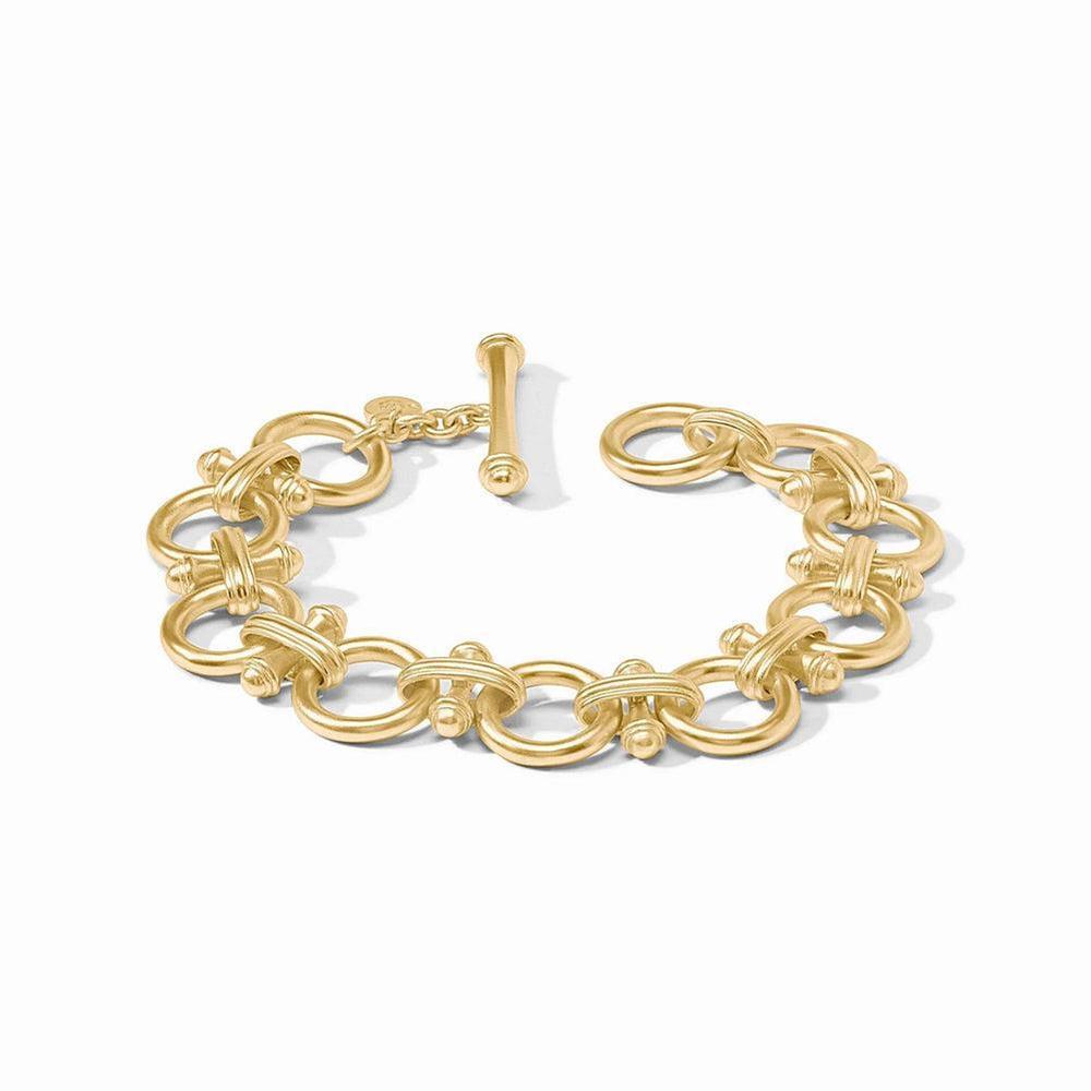 Gold statement bracelet with interlocking circular links and a toggle clasp.