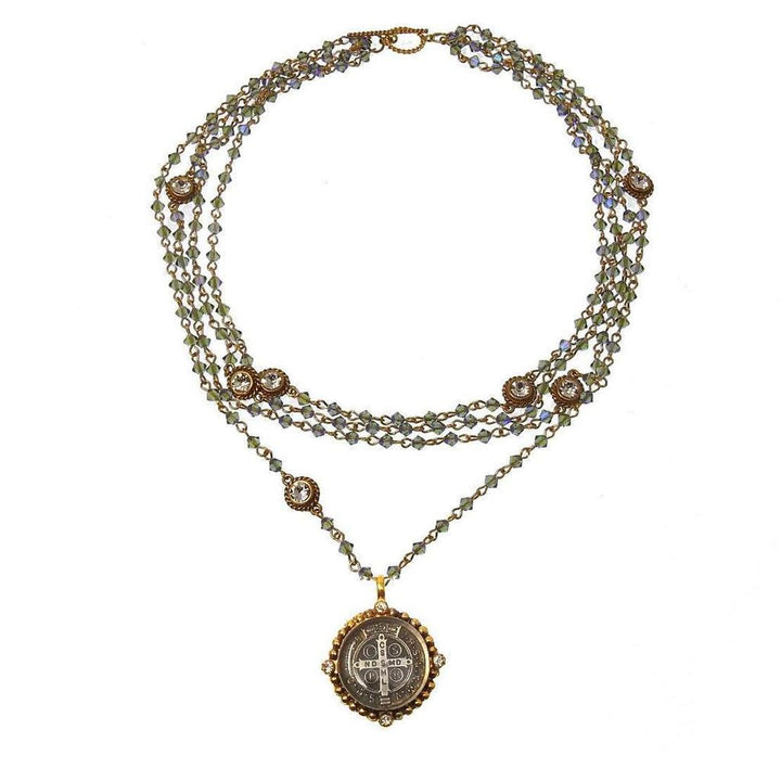 Layered metallic blue crystal necklace with a St. Christopher medal pendant.