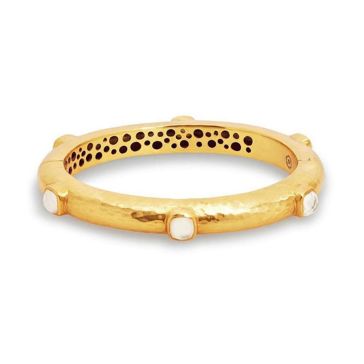Gold hinged bangle bracelet adorned with gemstones; hammered texture.