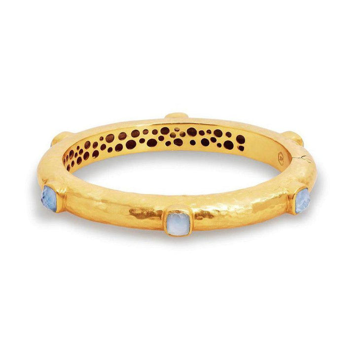 Gold hinged bangle bracelet adorned with pale blue gemstones.