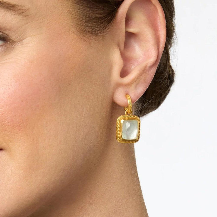 Gold hoop earrings with a square, pearly stone pendant.