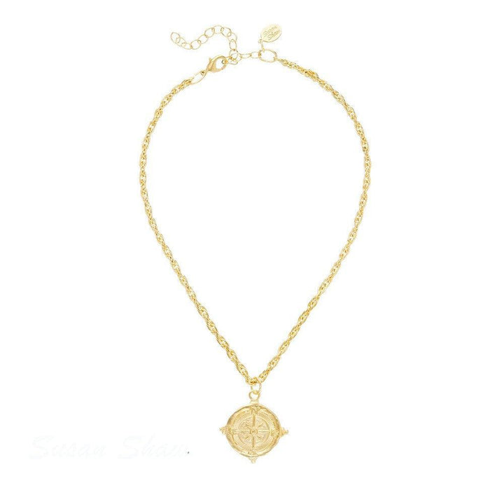 Gold compass pendant necklace with rope chain.