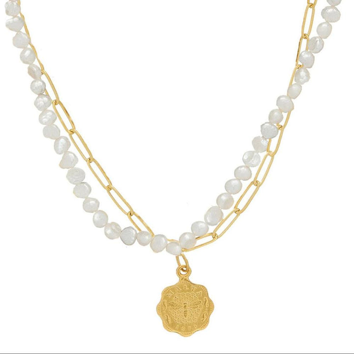 Dainty double strand necklace with white pearls, gold chain, and bee charm pendant.