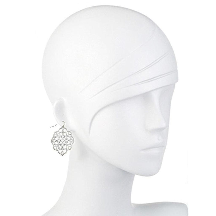 Silver filigree dangle earrings on a mannequin.