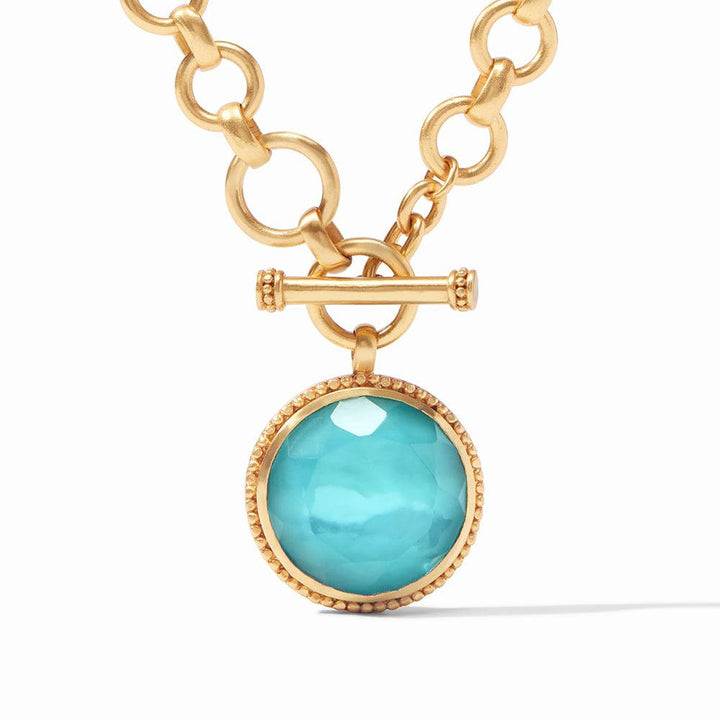 Gold chain necklace with turquoise gemstone pendant.