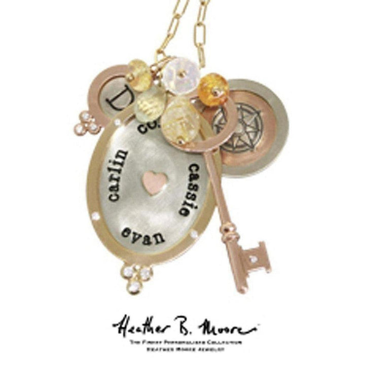 Rose gold personalized necklace featuring engraved oval charm, gemstone accents, and key charms.