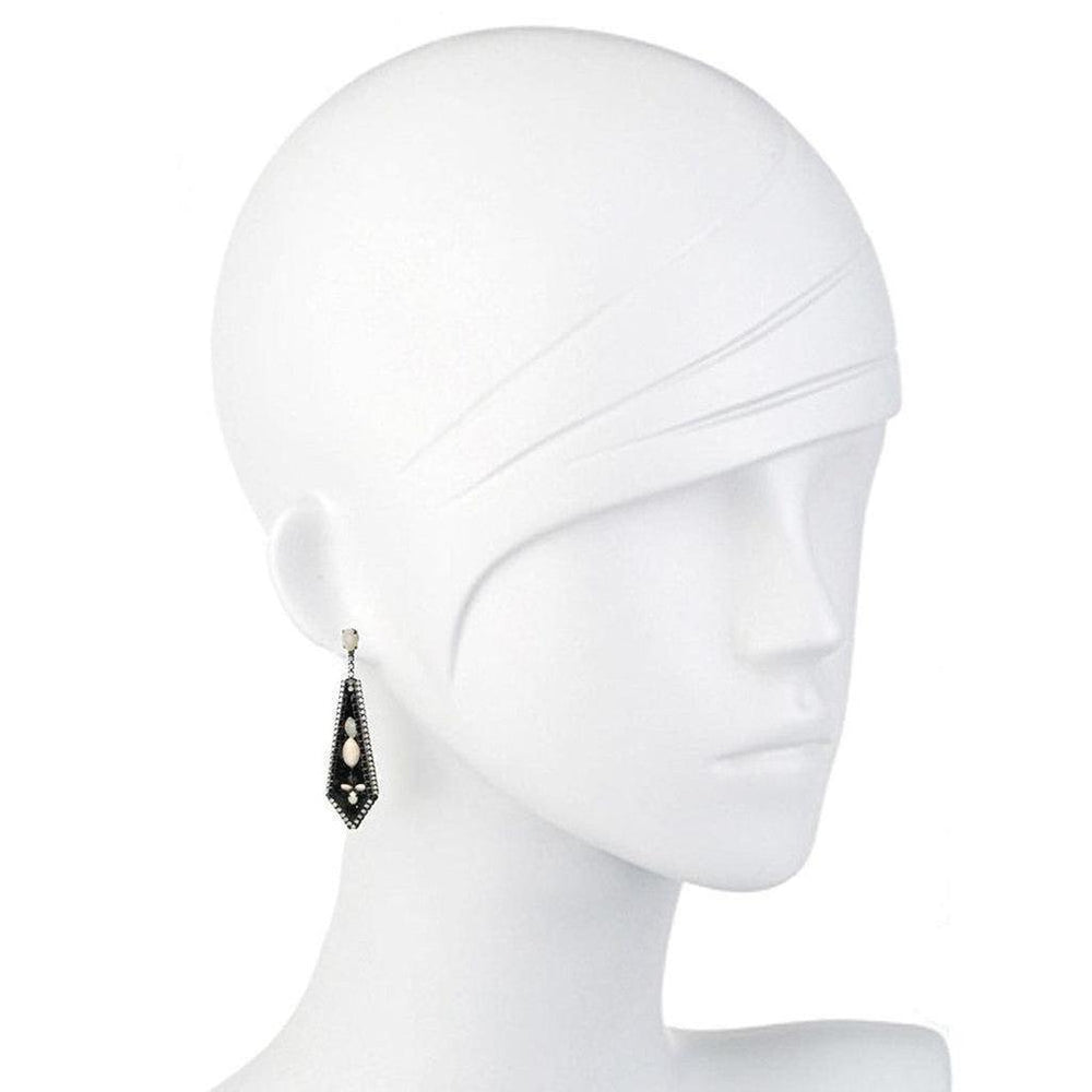 Black and white gemstone drop earrings on a mannequin.