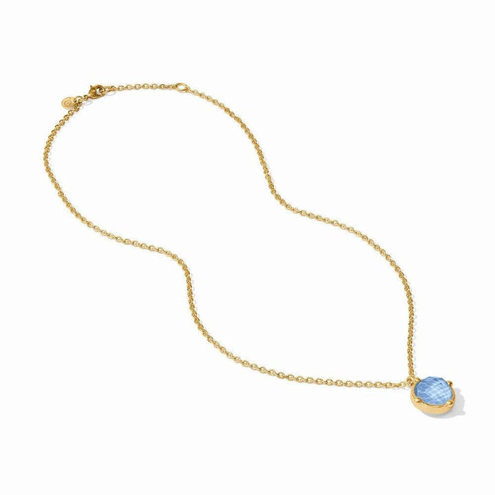 Gold chain necklace with a light blue gemstone pendant.