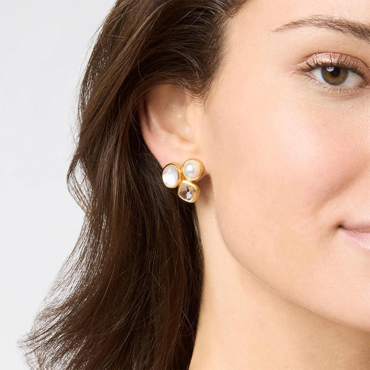 Gold stud earrings featuring a pearl and white stones.