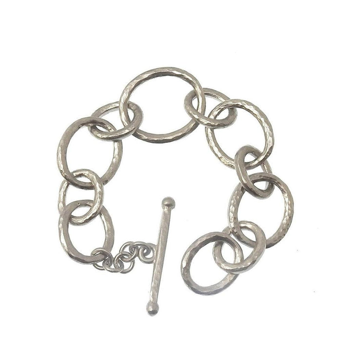 Silver link bracelet with hammered texture and toggle clasp.