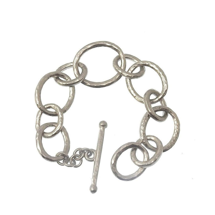 Silver link bracelet with hammered texture and toggle clasp.