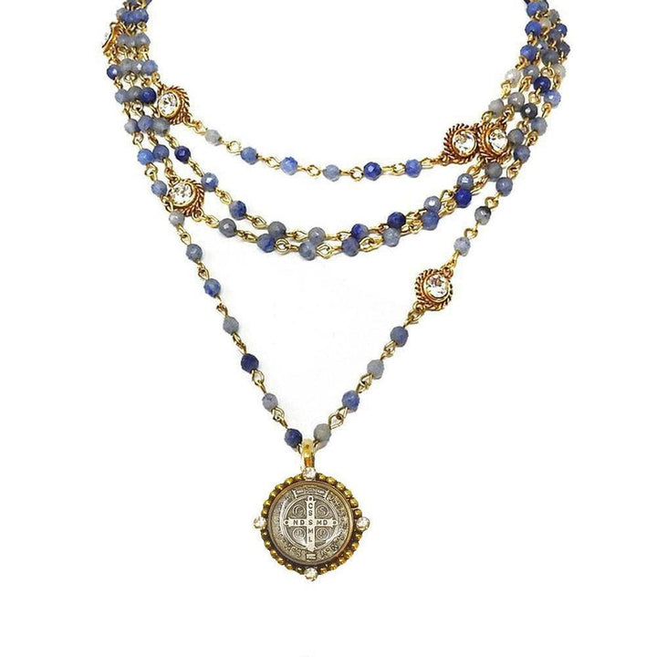 Magdalena in Gold Blue Obsidian necklace: layered blue gemstone & gold chain with ornate pendant.