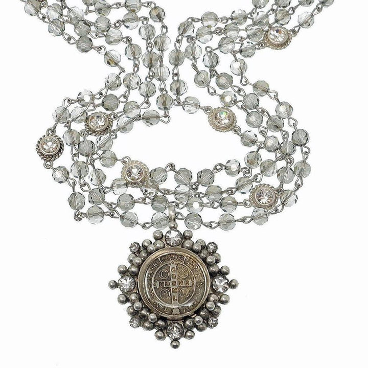 Multi-strand crystal bead necklace with ornate silver pendant.