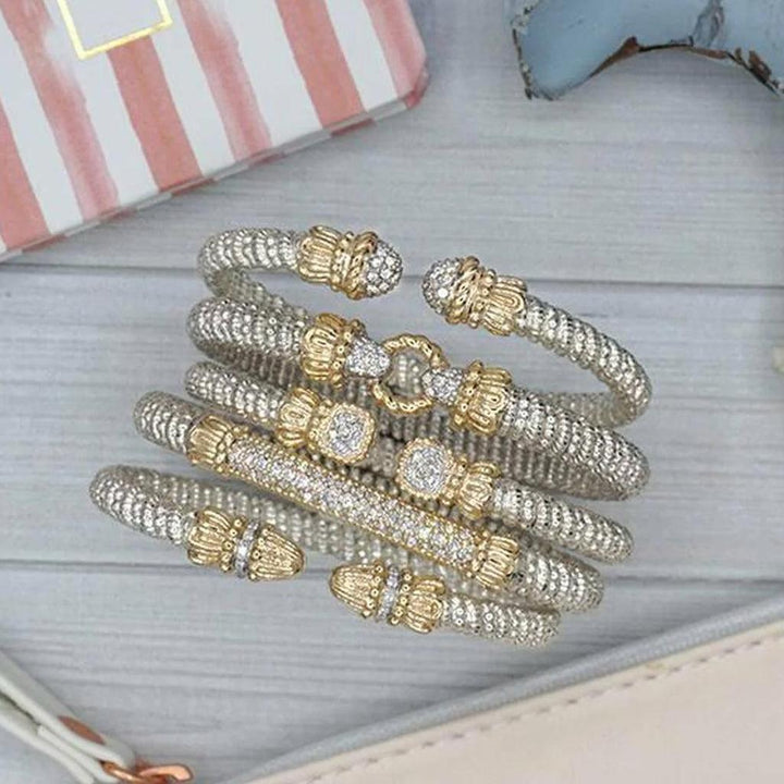 Stack of pave diamond bracelets in silver and gold; detailed close-up.