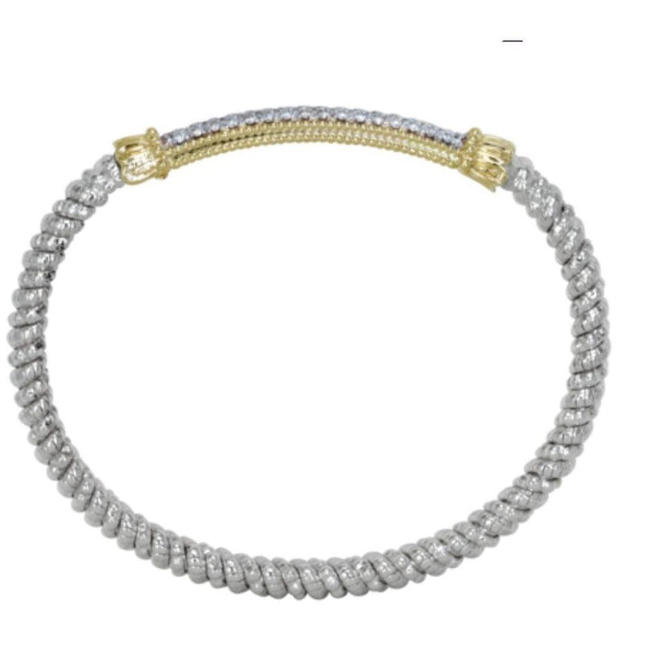 Twisted silver bangle bracelet with gold and diamond accents.