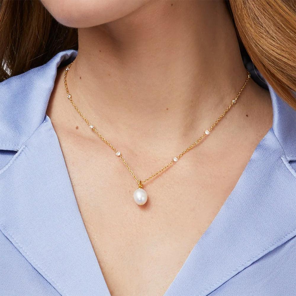 Gold chain necklace featuring a single pearl pendant and small clear stones.