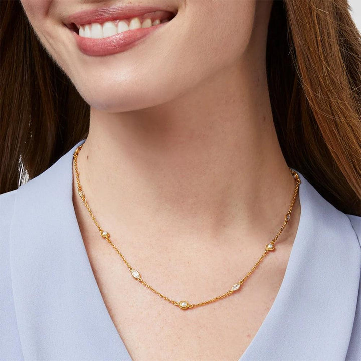 Gold chain necklace with clear stones, worn by a model.