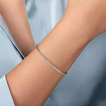 Diamond tennis bracelet in 14K two-tone gold on a wrist.
