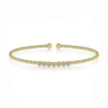 14K yellow gold beaded bangle featuring a row of sparkling cluster diamonds.
