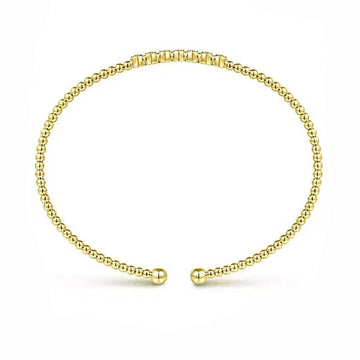 14K yellow gold beaded bangle featuring a cluster of diamonds.
