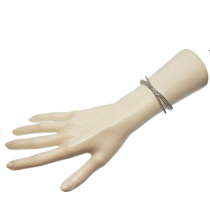 Silver cuff bracelet featuring three rows of sparkling crystals on a mannequin wrist.
