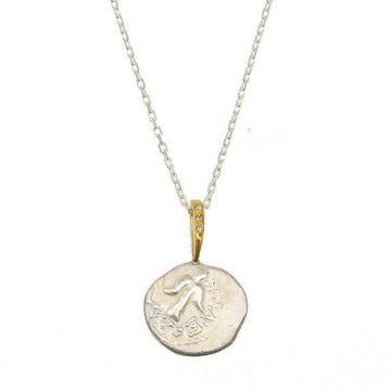 Angel in Flight necklace: silver coin pendant with engraved bird, gold accents & diamonds, delicate chain.
