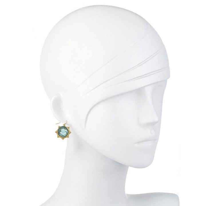 Aqua glass fleur-de-lis earrings on a mannequin.
