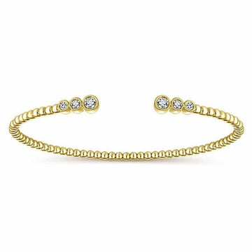Gold beaded bangle bracelet featuring three bezel-set diamonds.

