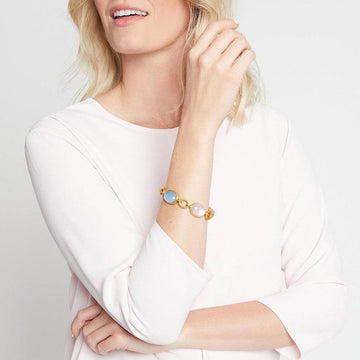 Gold chain bracelet featuring pale pink and blue gemstones.
