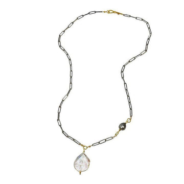 Elegant baroque pearl necklace with dark metal chain and smaller pearl accent.
