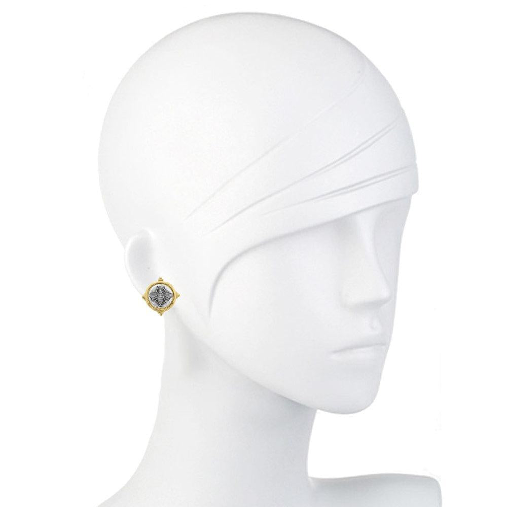 Intaglio bee design on gold-toned clip earrings, shown on a mannequin.

