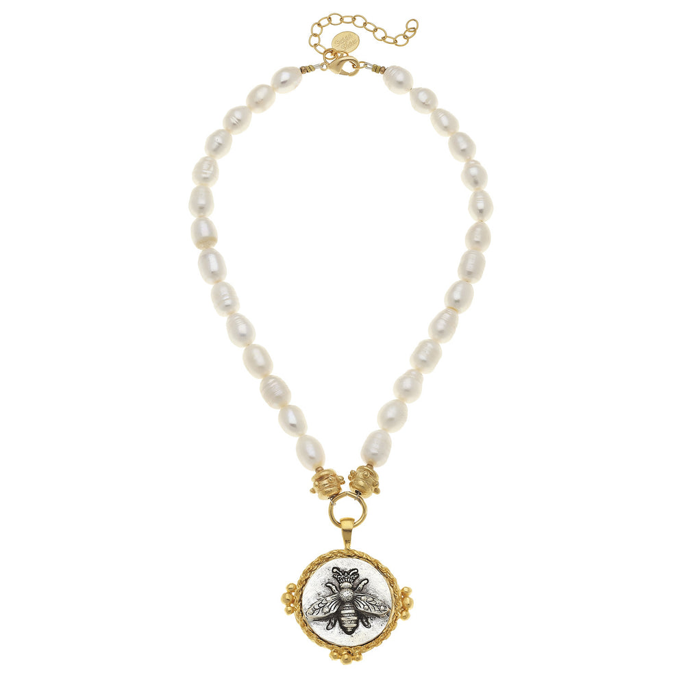Elegant pearl necklace featuring a gold bee intaglio pendant.
