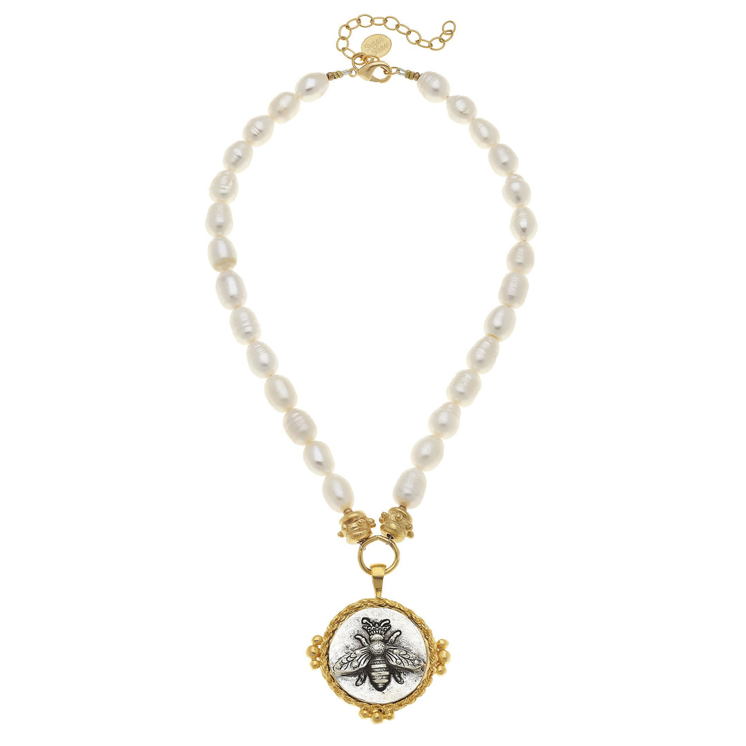Elegant pearl necklace featuring a gold bee intaglio pendant.
