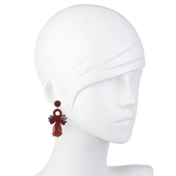 Red tassel earrings with a circular accent, displayed on a mannequin.
