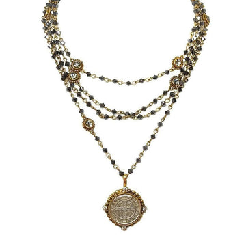Layered gold hematite necklace with a silver medallion pendant and clear crystal accents.
