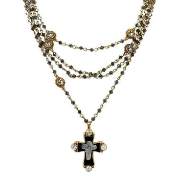 Layered black crystal and gold necklace featuring a detailed cross pendant.
