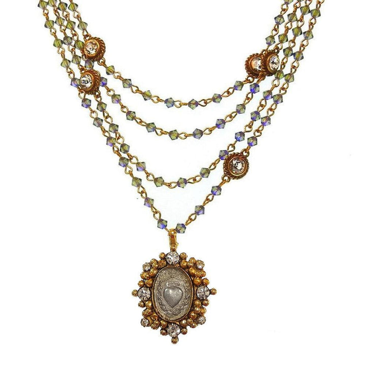 Layered gold necklace with iridescent beads and a heart-shaped pendant.
