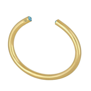Gold bangle bracelet featuring light blue gemstones.

