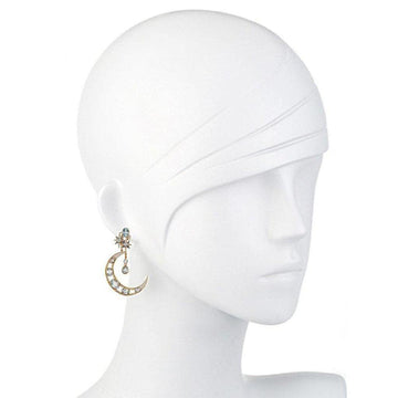 Crescent moon earrings with blue topaz and star accents, displayed on a mannequin.
