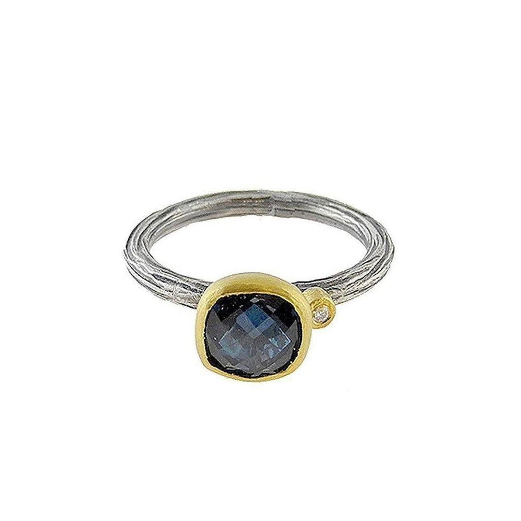 Textured silver & gold ring featuring a cushion-cut blue topaz.
