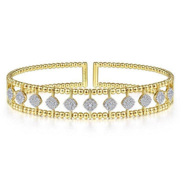 Gold cuff bracelet featuring beaded detailing and sparkling diamond accents.
