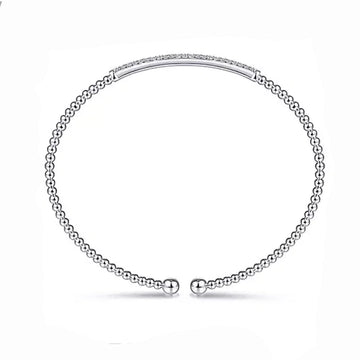 White gold beaded bangle bracelet featuring a diamond-encrusted bar.

