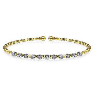 Gold beaded cuff bracelet accented with sparkling diamond stations.

