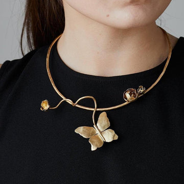 Gold butterfly choker necklace with floral accents.
